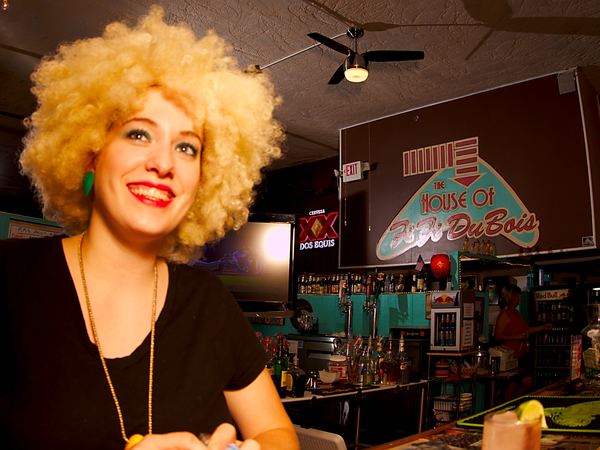 Smiling guest in a retro wig at the bar