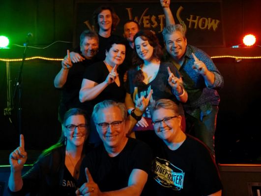 Band and fans posing after a show